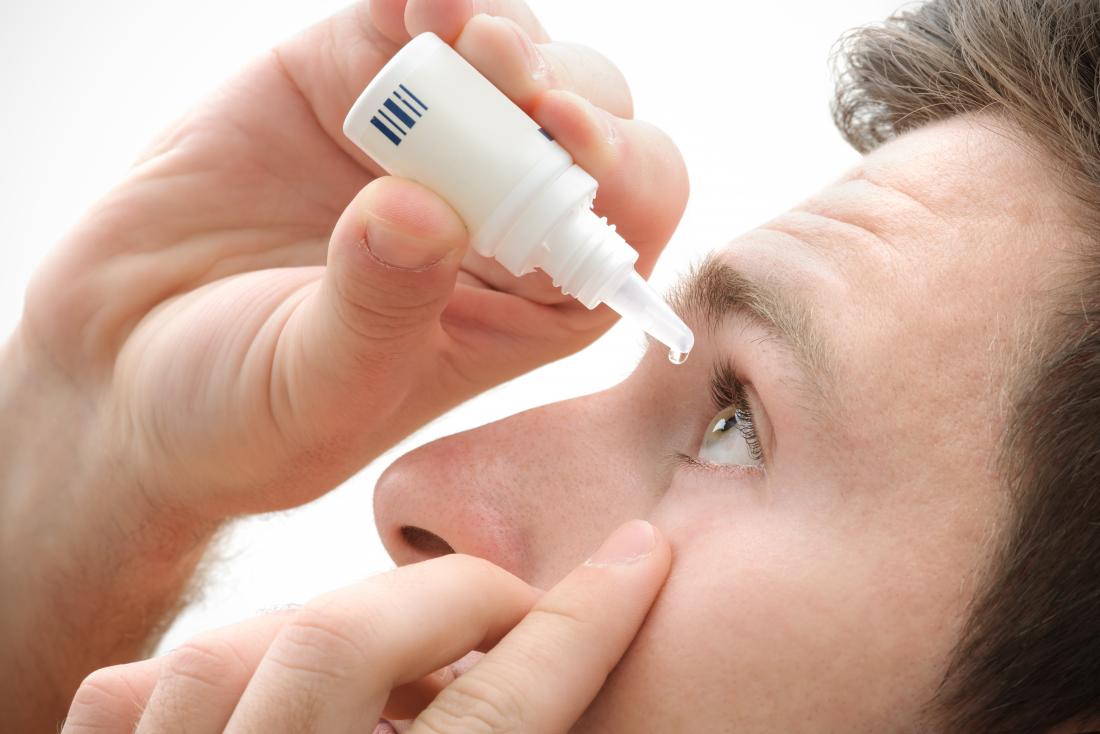 man using saline eyedrops to combat allergic reactions